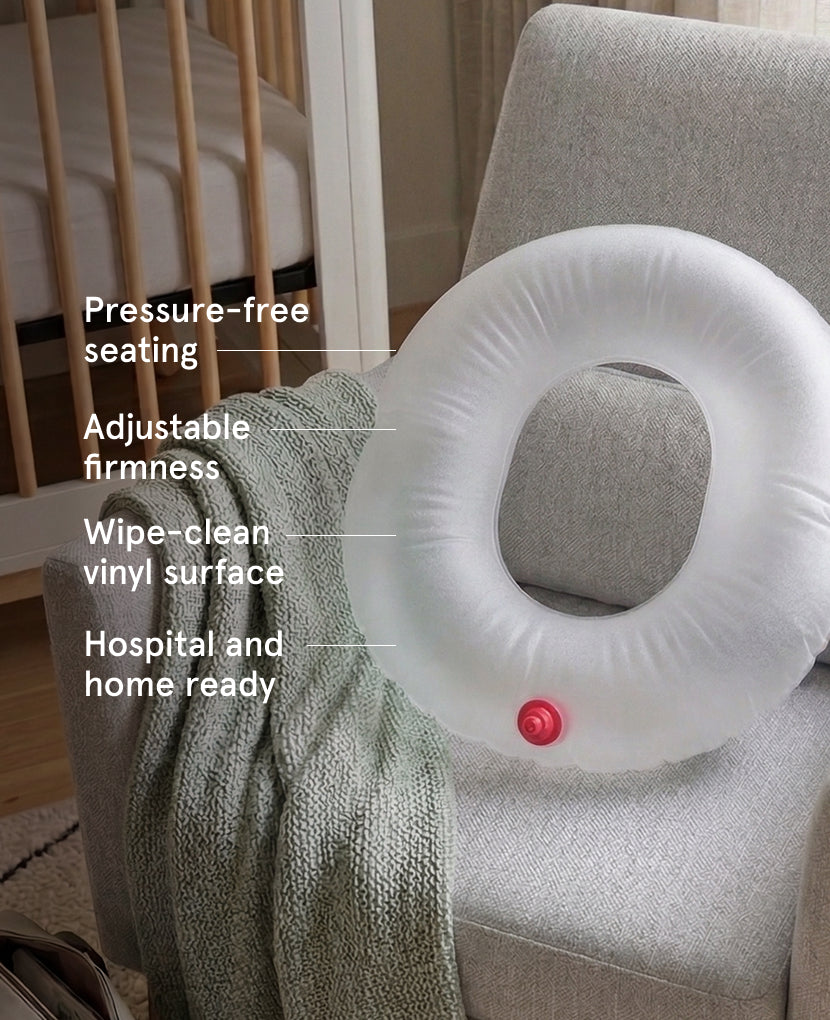The Inflatable Cushion, featuring a circular hole, sits on a gray armchair beside a green knit blanket. It offers pressure-free seating, adjustable firmness, an easy-to-clean vinyl cover, and is suitable for hospital or home use.