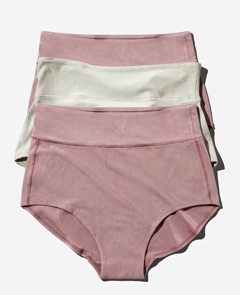 The All-In Panty: 3-Pack (Save 16%) features three high-waisted maternity underwear—two dusty pink and one off-white—neatly stacked on a white background for comfortable postpartum support.