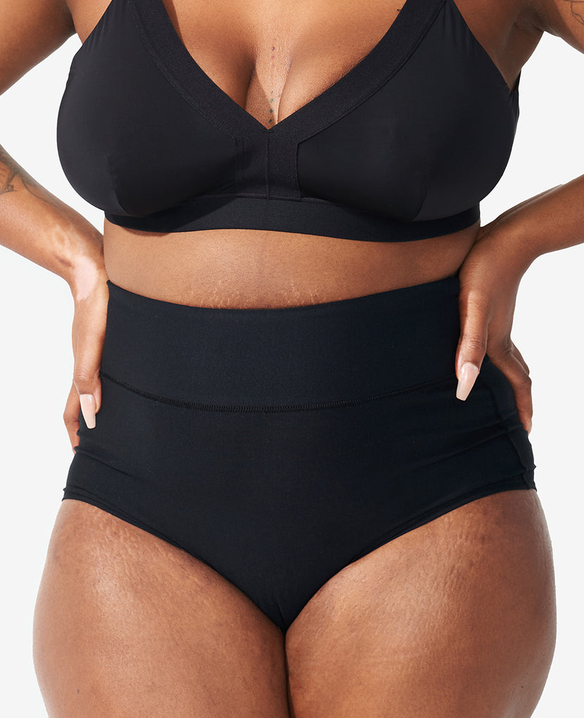 Person wearing a black bra and panty set on a neutral background in Black/Dusk/Slate