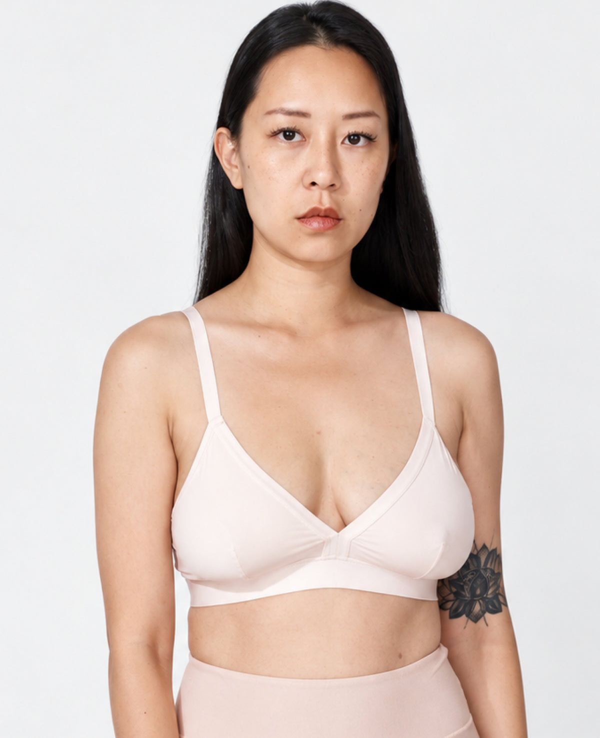Woman wearing a shell bra on a plain background. Shown in Shell.