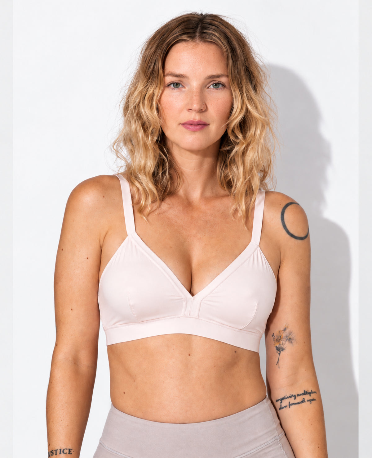 Woman wearing a shell bra on a plain background. Shown in Shell.
