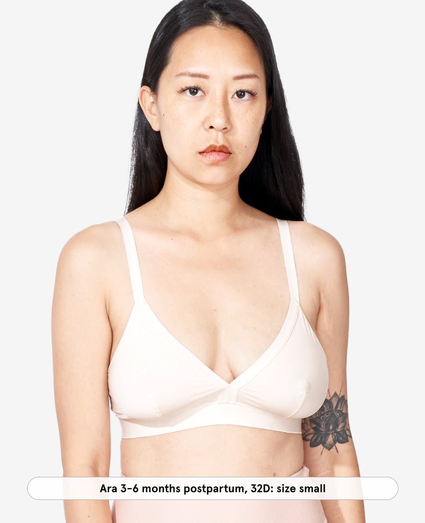 Woman wearing a shell bra on a plain background