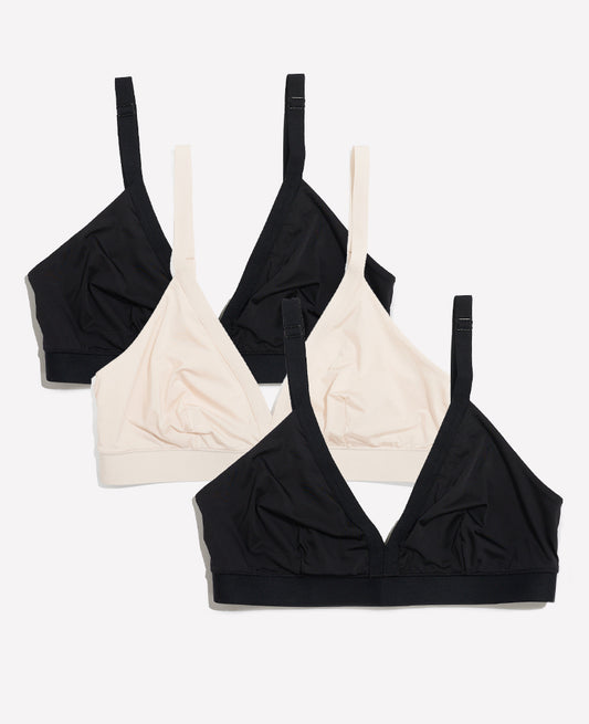 The So Easy Bra: 3-Pack • Save 14%—three wireless bralettes (two black, one beige) with adjustable straps and a simple, unpadded design, perfect for nursing or maternity, are overlapped on a plain white background.