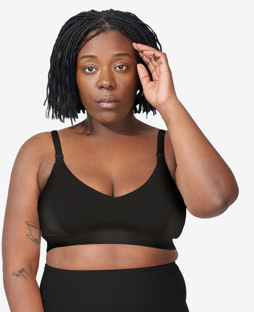 Sizes L and XL feature thicker straps for comfort. The V-shaped neckline and smoothing fabric layer easily under clothes. Tahirah, size 38D, wears a L in Black.