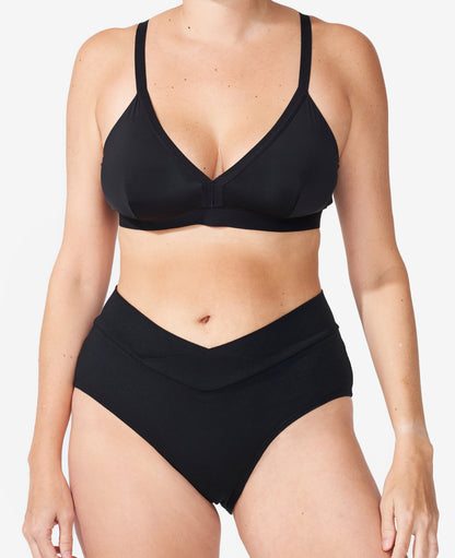 The Embrace Crossover Postpartum Panty is craveably soft with a flattering crossover style. Danielle, size 2 and 5 months postpartum, wears size Small in Black.