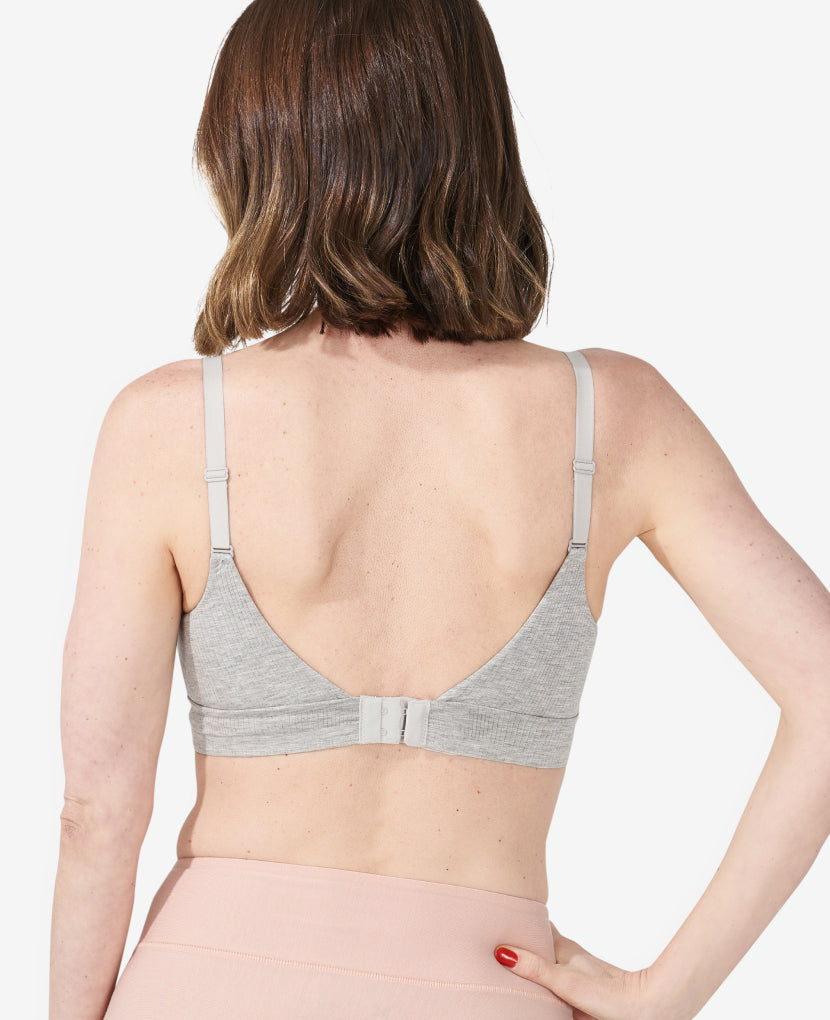 Unlike traditional pull-down nursing bras, an open back design combined with high side panels gives balanced coverage that gently smooths without any bulk. Nora, 34C, is 6 months postpartum wearing a size S in Grey Marl. 