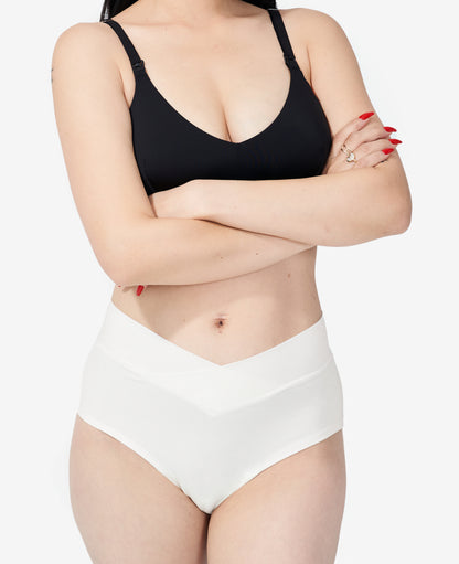 The Embrace Crossover Postpartum Panty is craveably soft, ultra-stretchy to flex with fluctuations, and has a flattering crossover style. Ara wears size Small in Chalk.