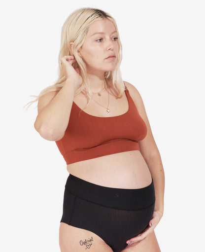 Designed to comfortably fit your body from maternity through every stage of breastfeeding and beyond. Ruby, in her third trimester, wears Ember.